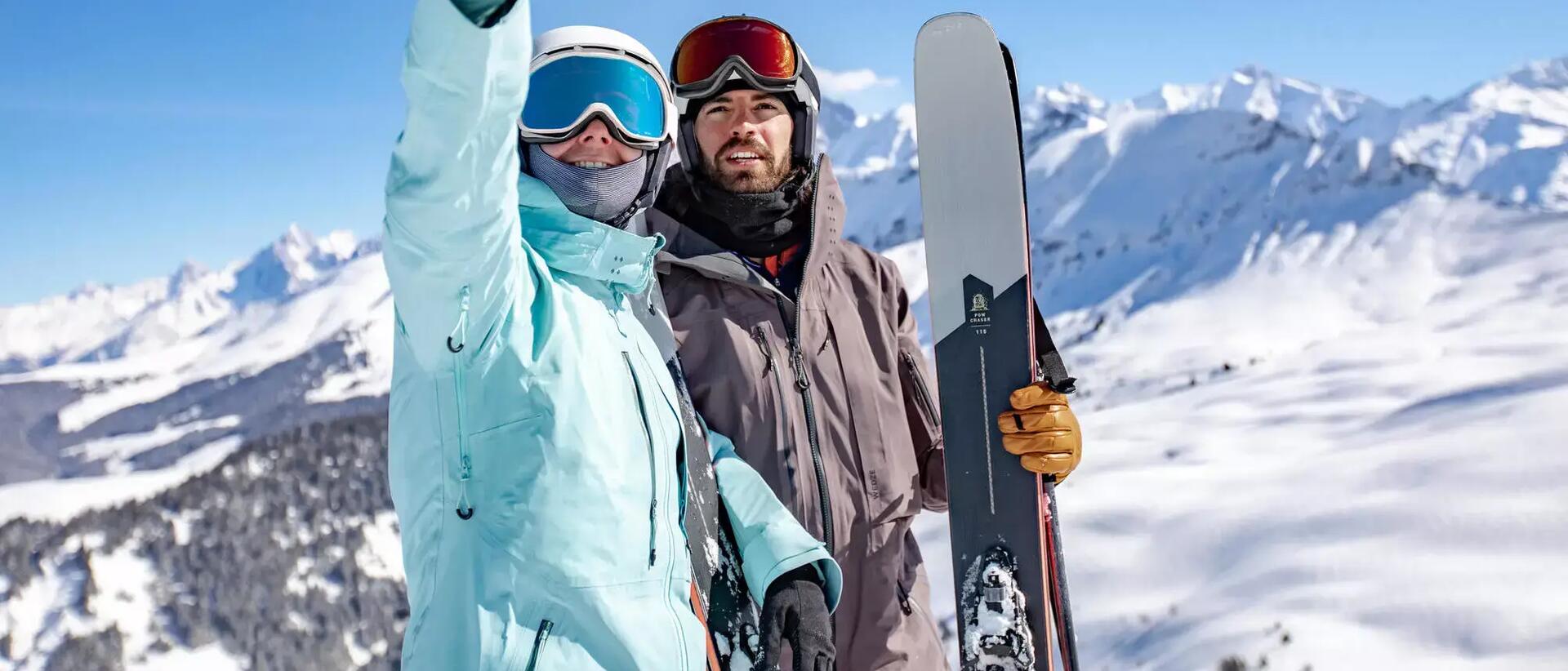 kobieta i mężczyzna w strojach narciarskich robią zdjęcie w górach