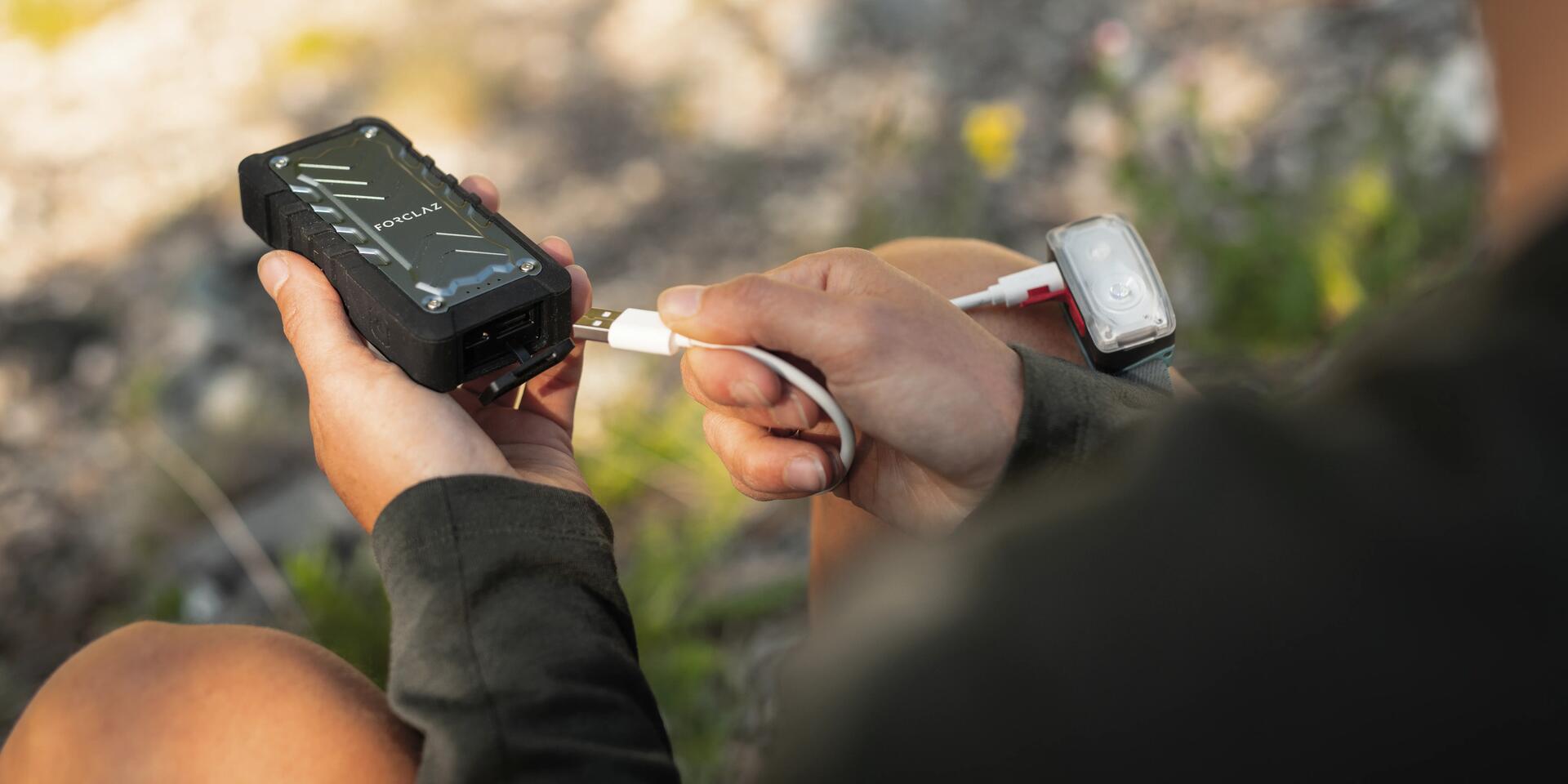 mężczyzna podłączający kabel do powerbanku