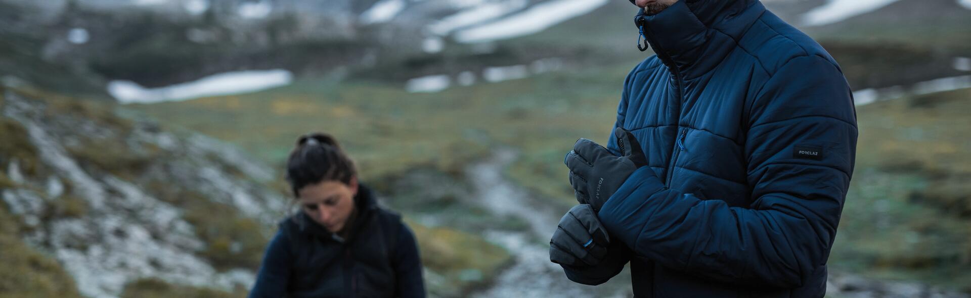kobieta i mężczyzna w rękawiczkach i kurtce puchowej w górach