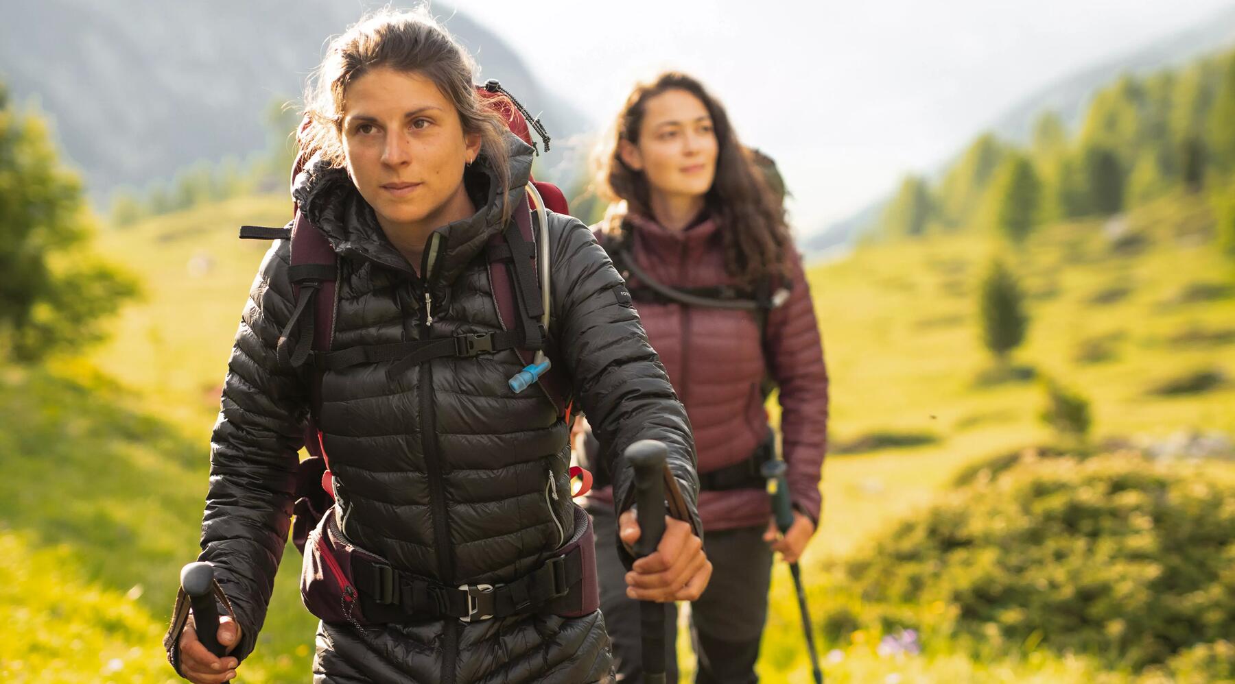 Zwei Frauen wandern in der Natur mit Nordic Walking Stöcken