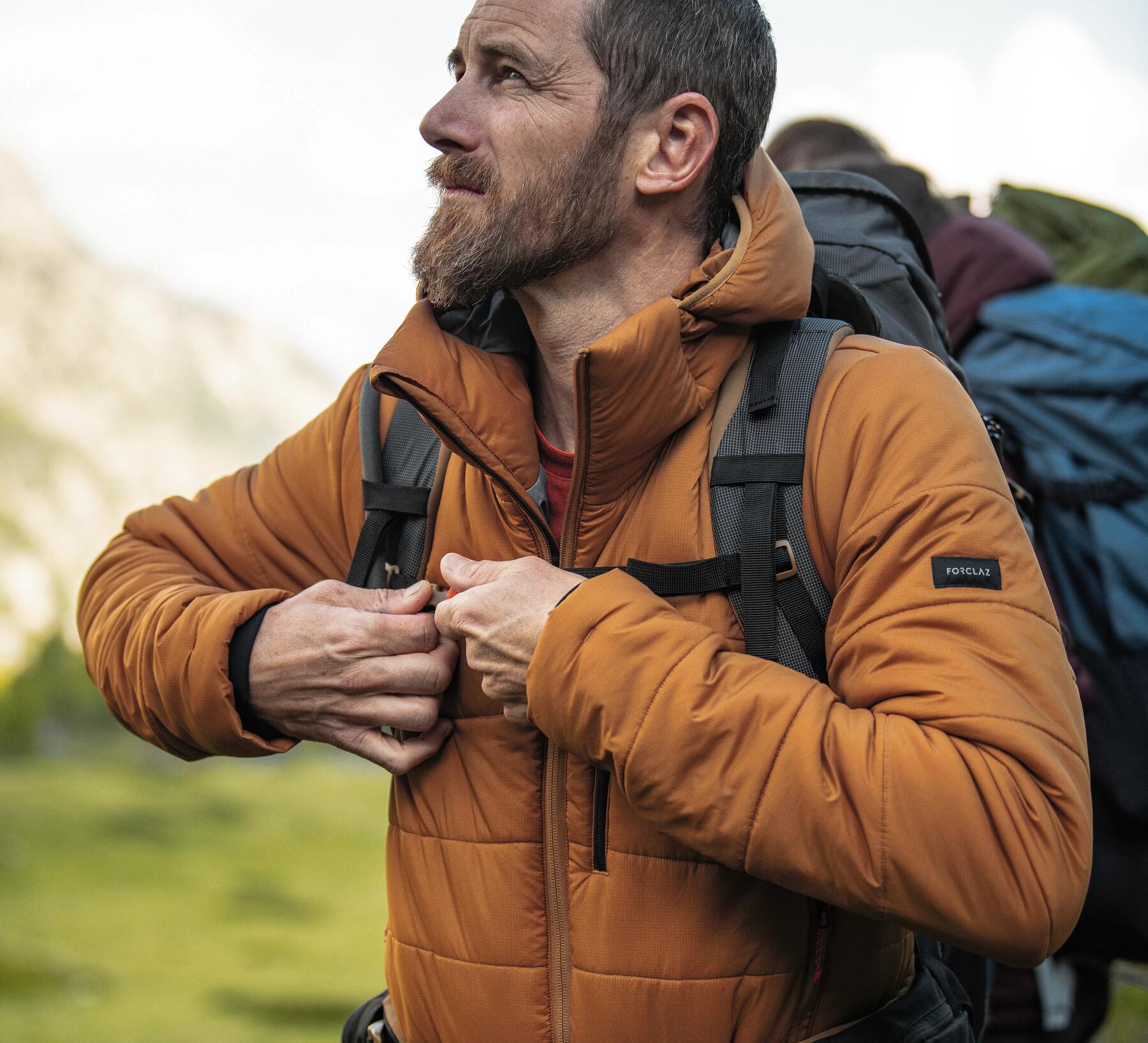 mężczyzna w kurtce trekkingowej z plecakiem turystycznym na plecach 