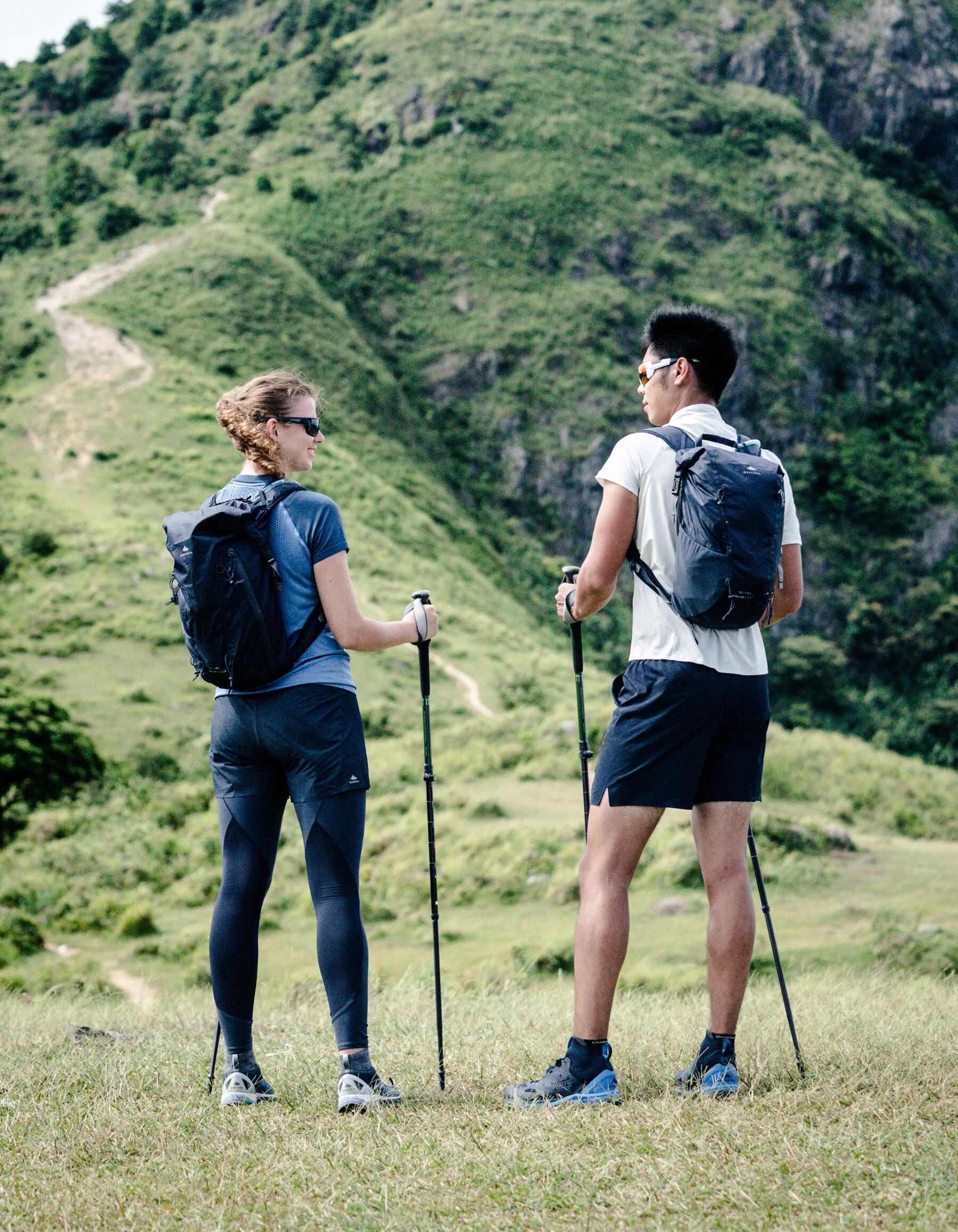 Zwei Wanderer mit Wanderstöcken stehen im Gebirge