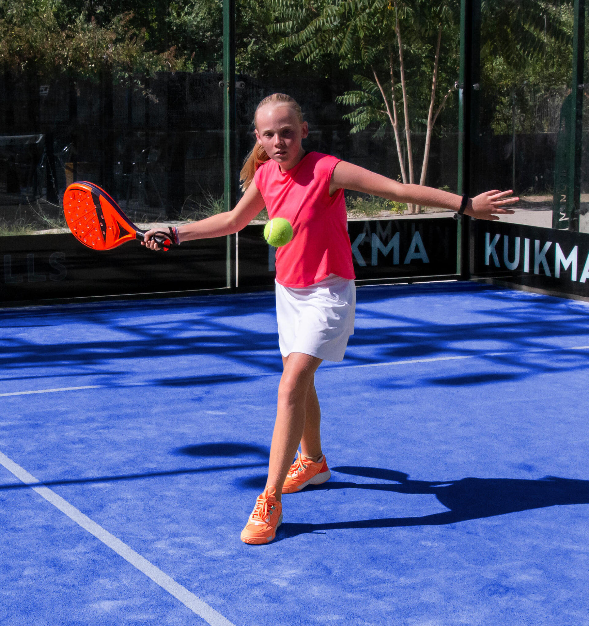 Girl playing padel on outdoor court
