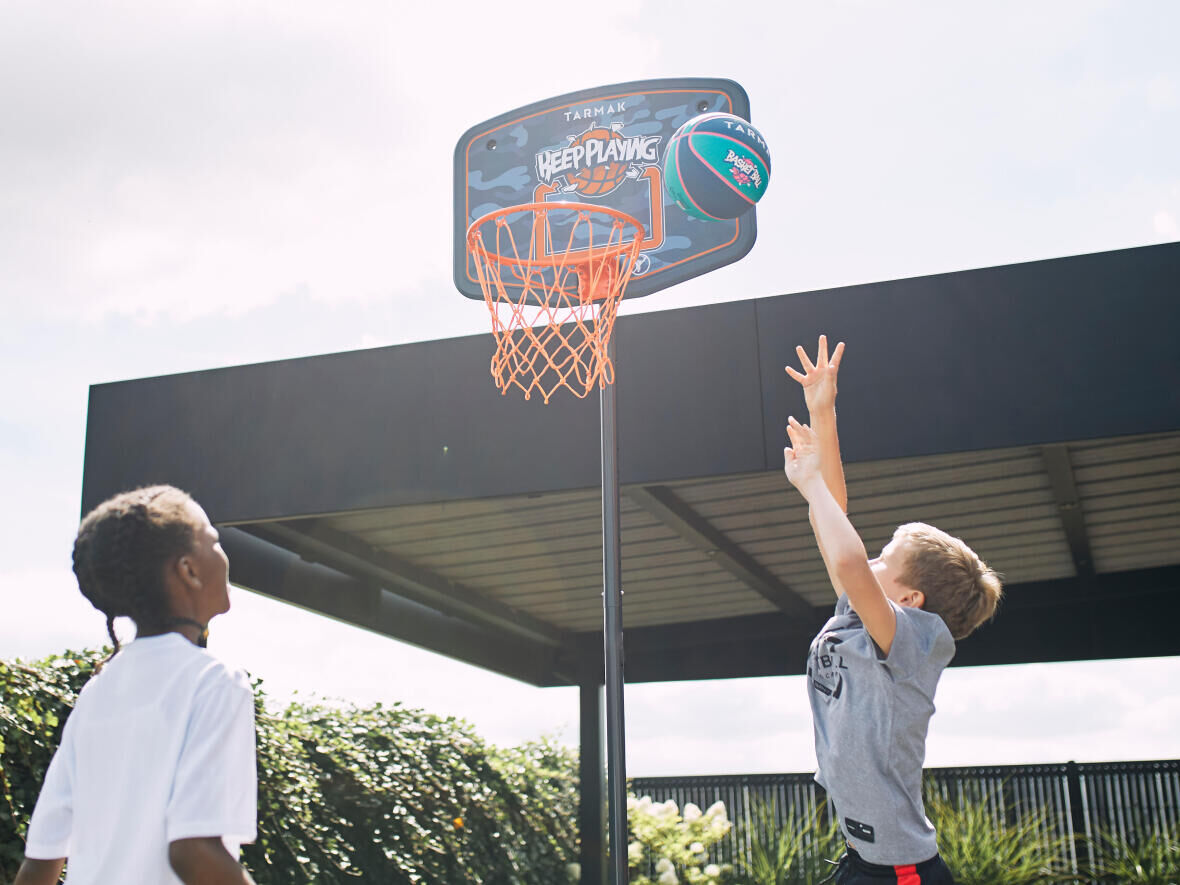 Dois meninos a praticar basquetebol