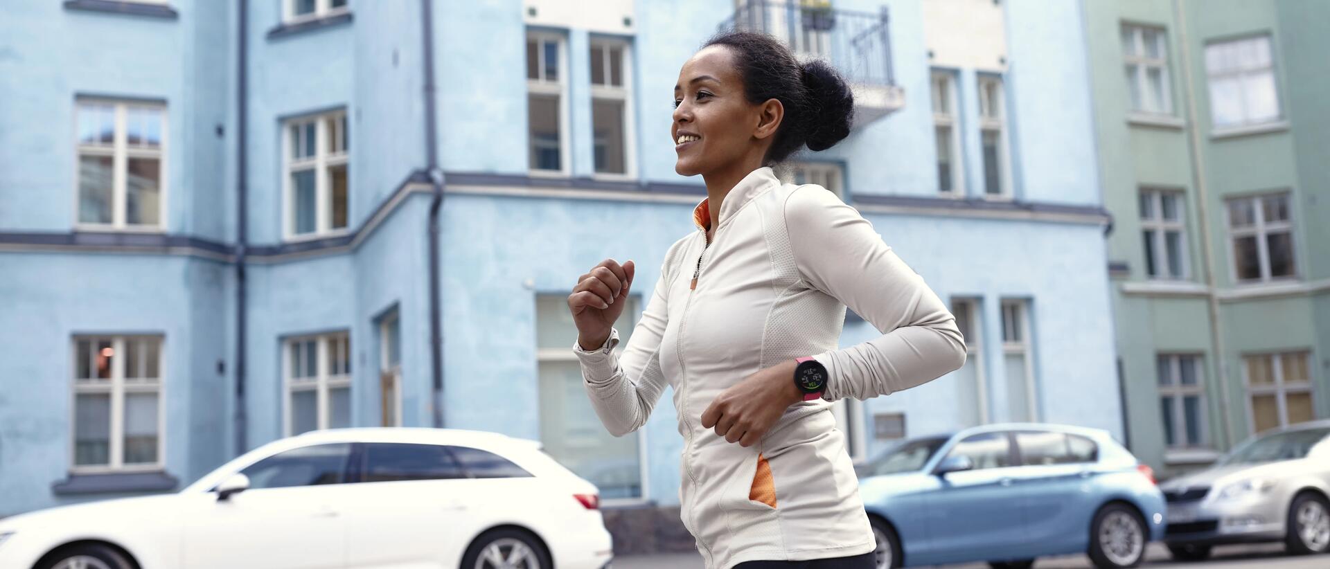 kobieta biegnąca w stroju sportowym z pulsometrem na ręce