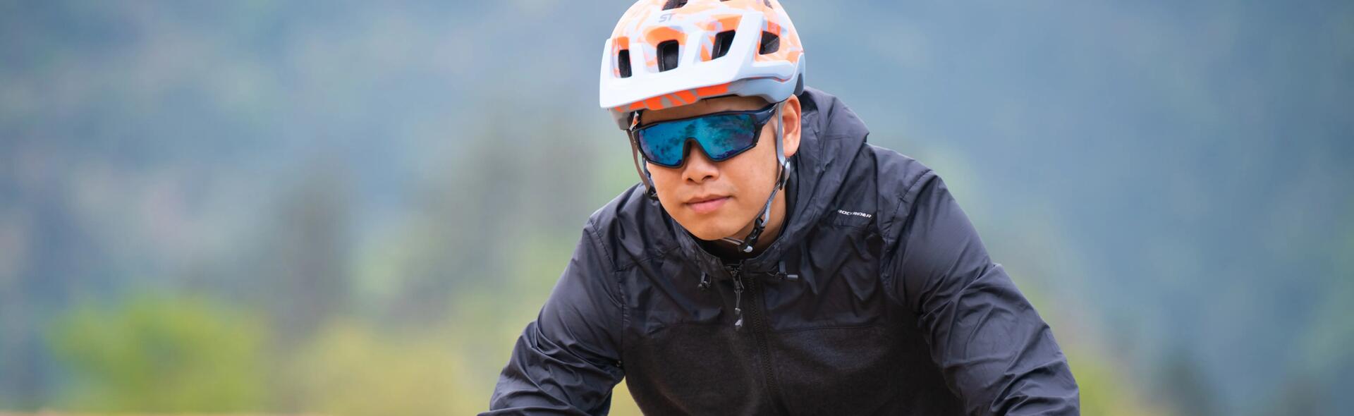 mężczyzna jadący na rowerze w okularach rowerowych  i kasku