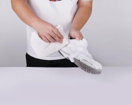 mężczyzna czyszczący buty sportowe