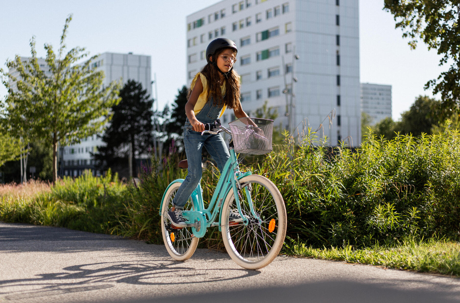 En flicka cyklar i ett urbant lägehetsområde