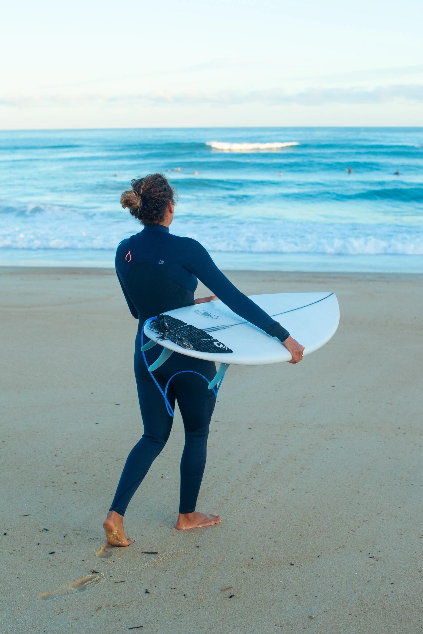 Lady carrying her surfboard