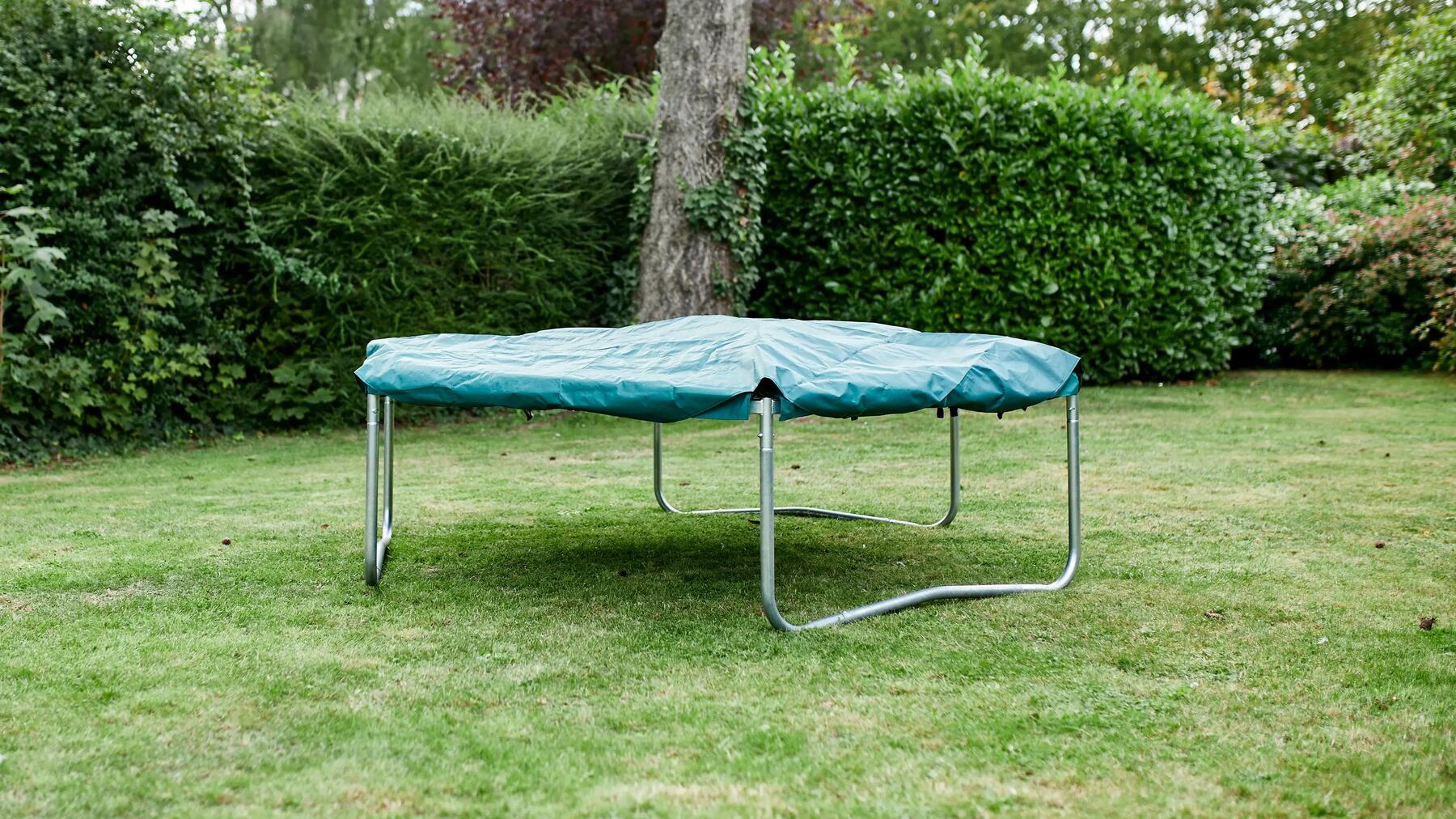 Ein rundes Trampolin steht im Garten