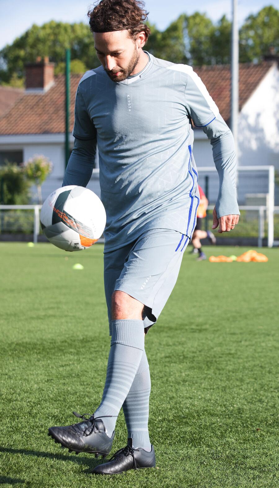 Mann hält einen Fußball hoch