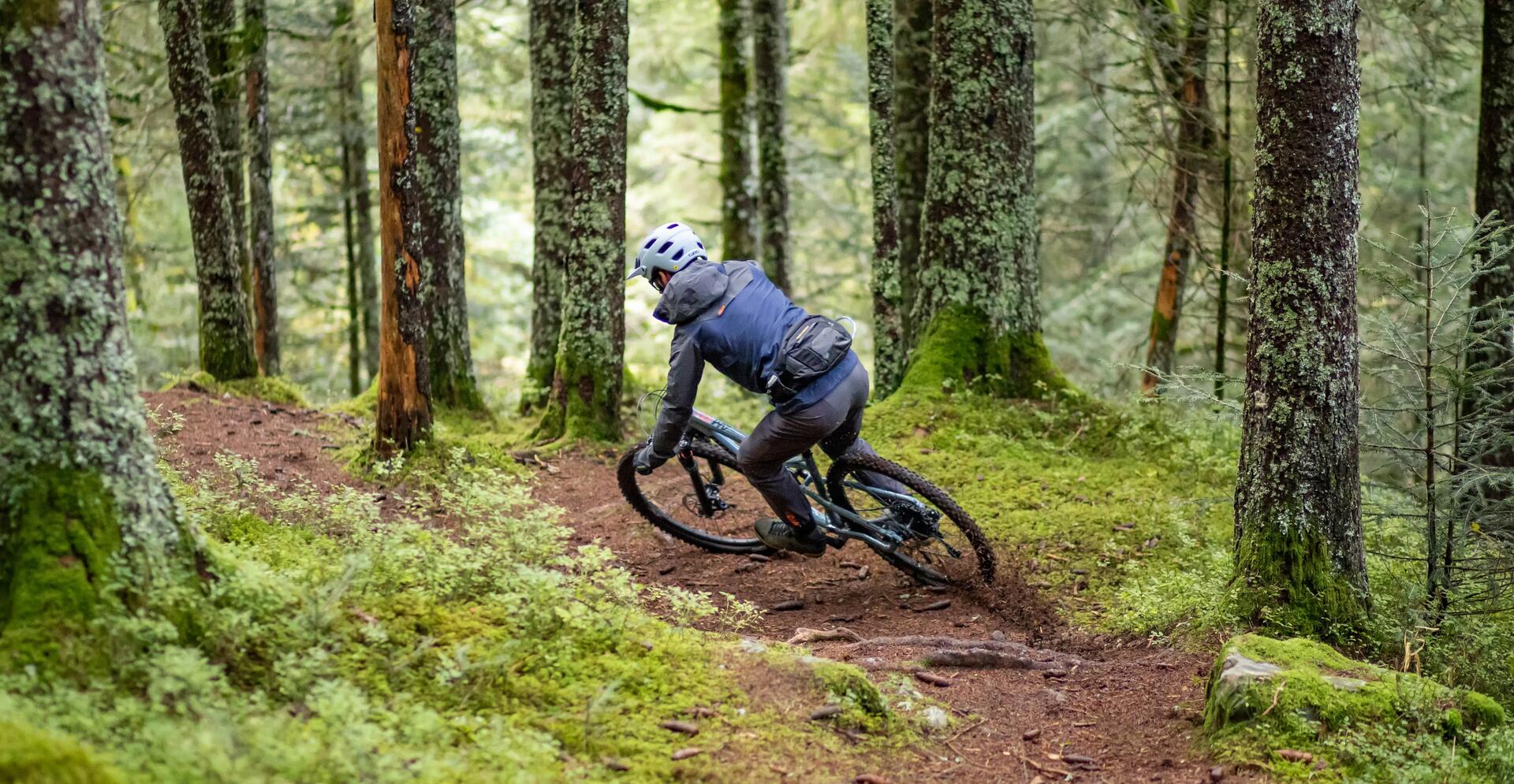 mężczyzna jadący na rowerze XC w kasku przez las