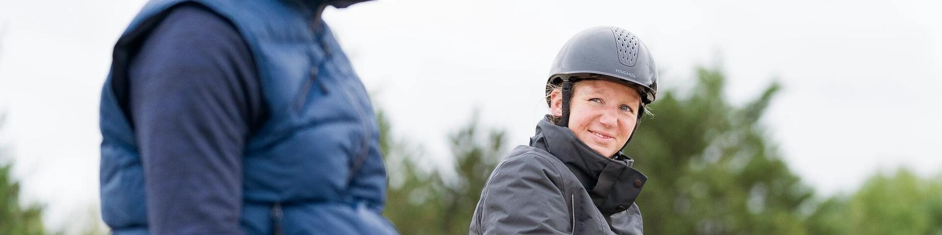 A women wearing a Fouganza Horse Riding Helmet on a Horse