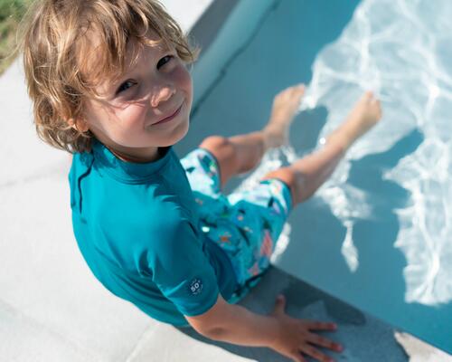 Kind mit UV-Shirt am Wasser