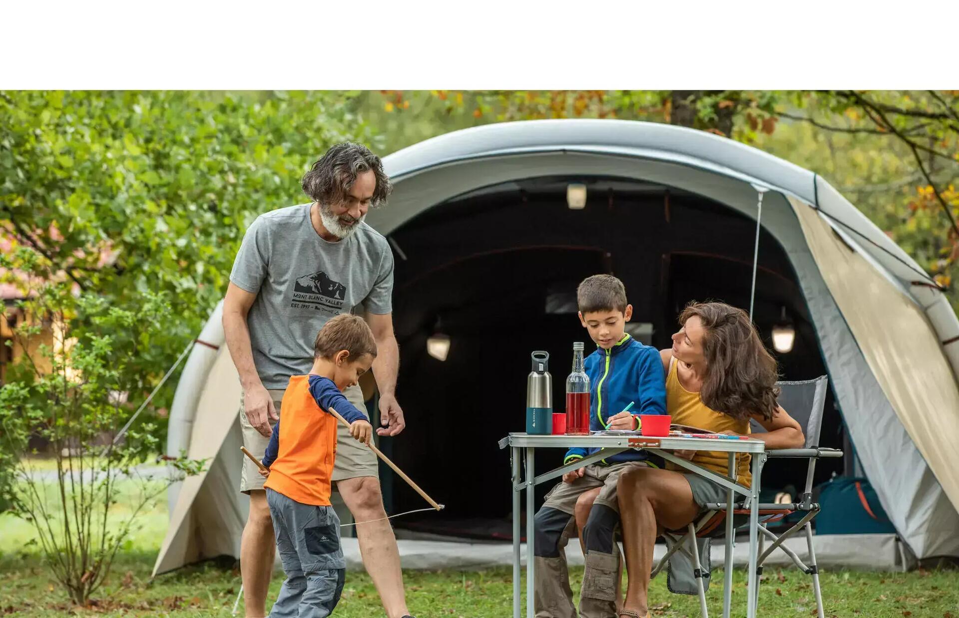 Family camping outside in greenery