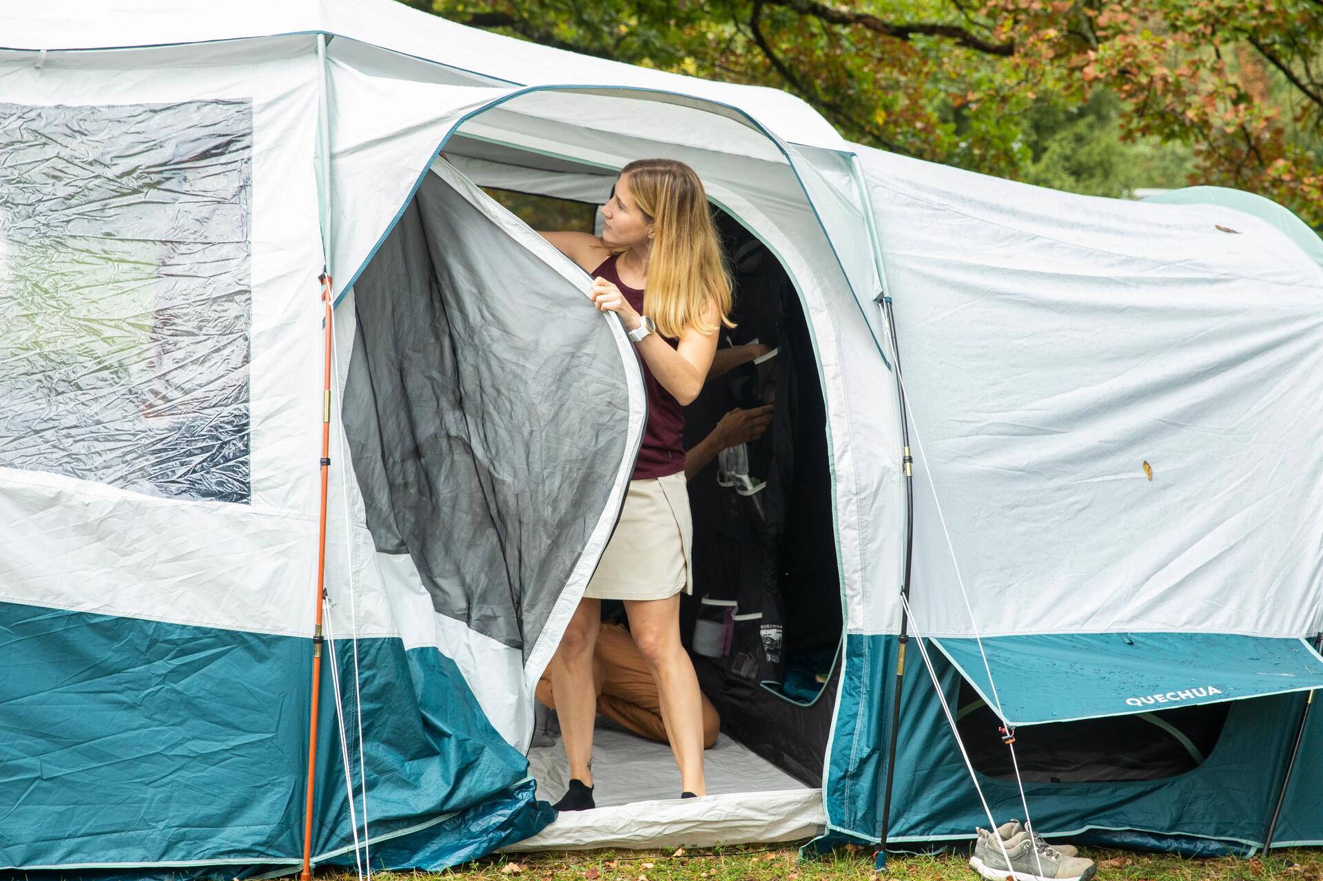 Kobieta otwierająca drzwi wejściowe do namiotu zapobiegając kondensacji pary wodnej