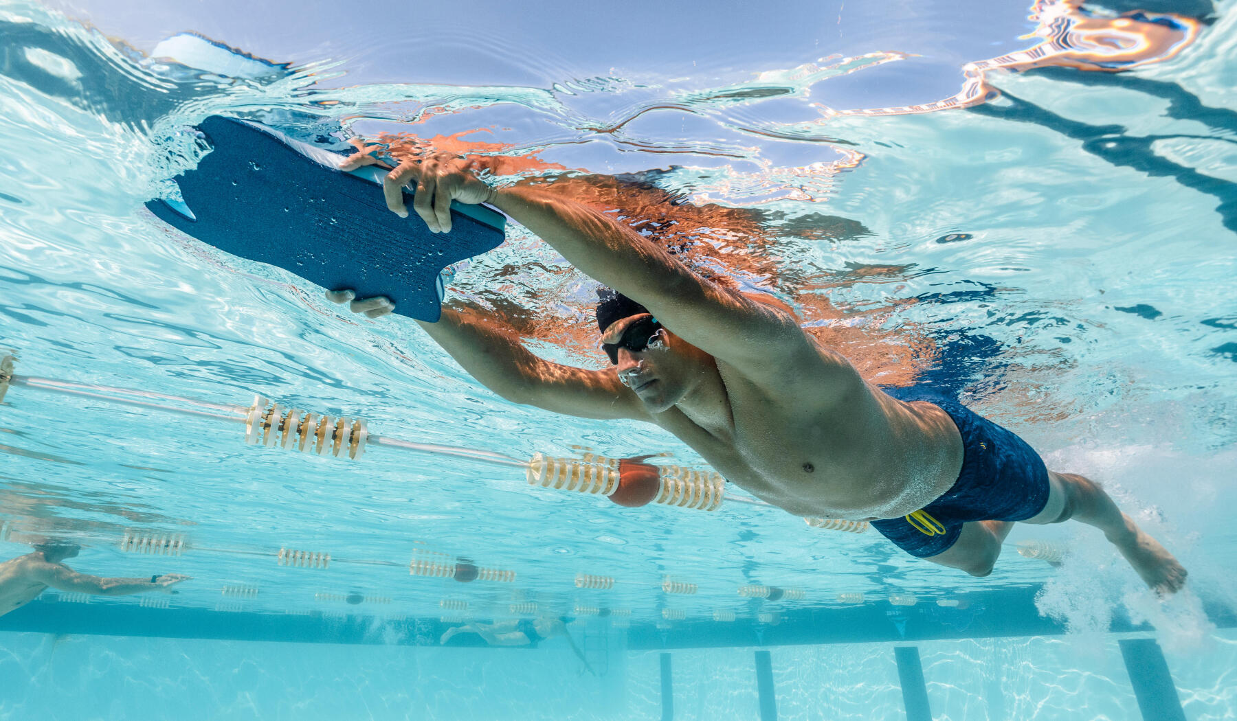 Nageur qui utilise une planche de natation comme accessoire d'entrainement