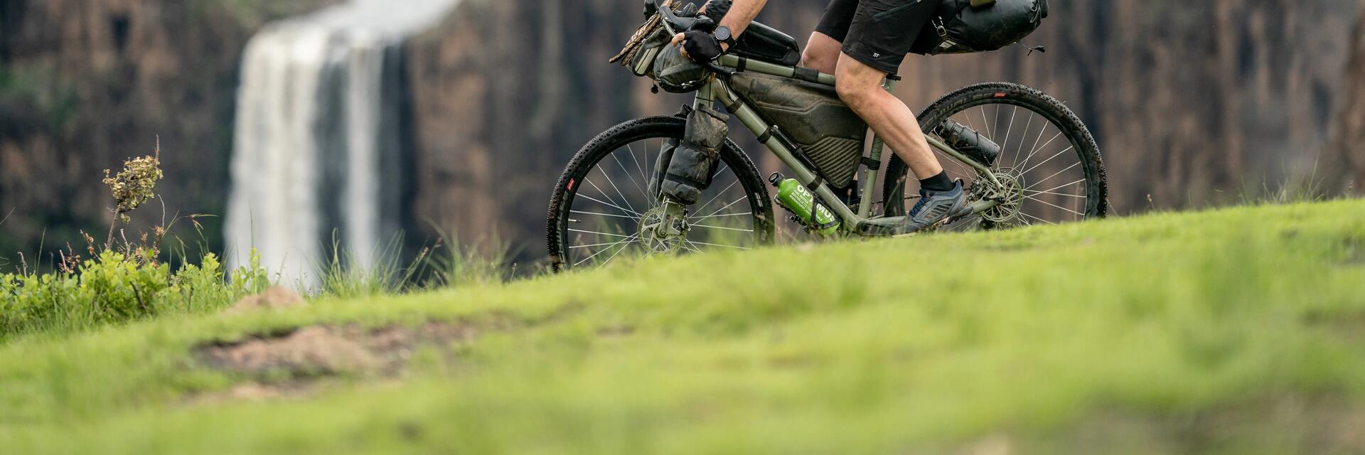 Rowerzysta w kasku jadący rowerem w terenie