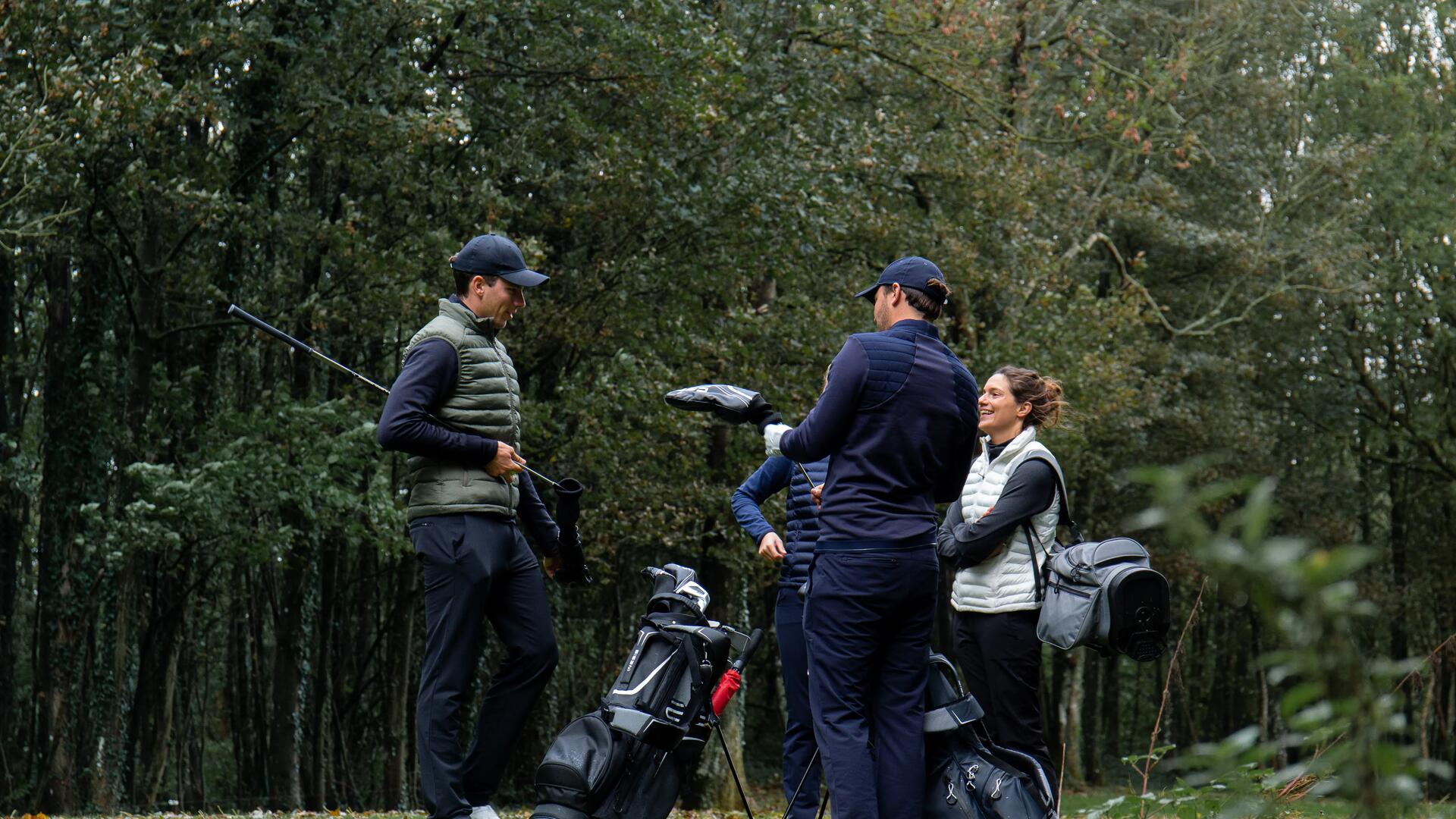 kobiety i mężczyźni stojący w plenerze z kijami i torbami golfowymi