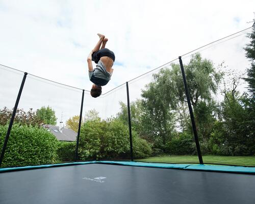 chłopiec wykonujący salto na trampolinie