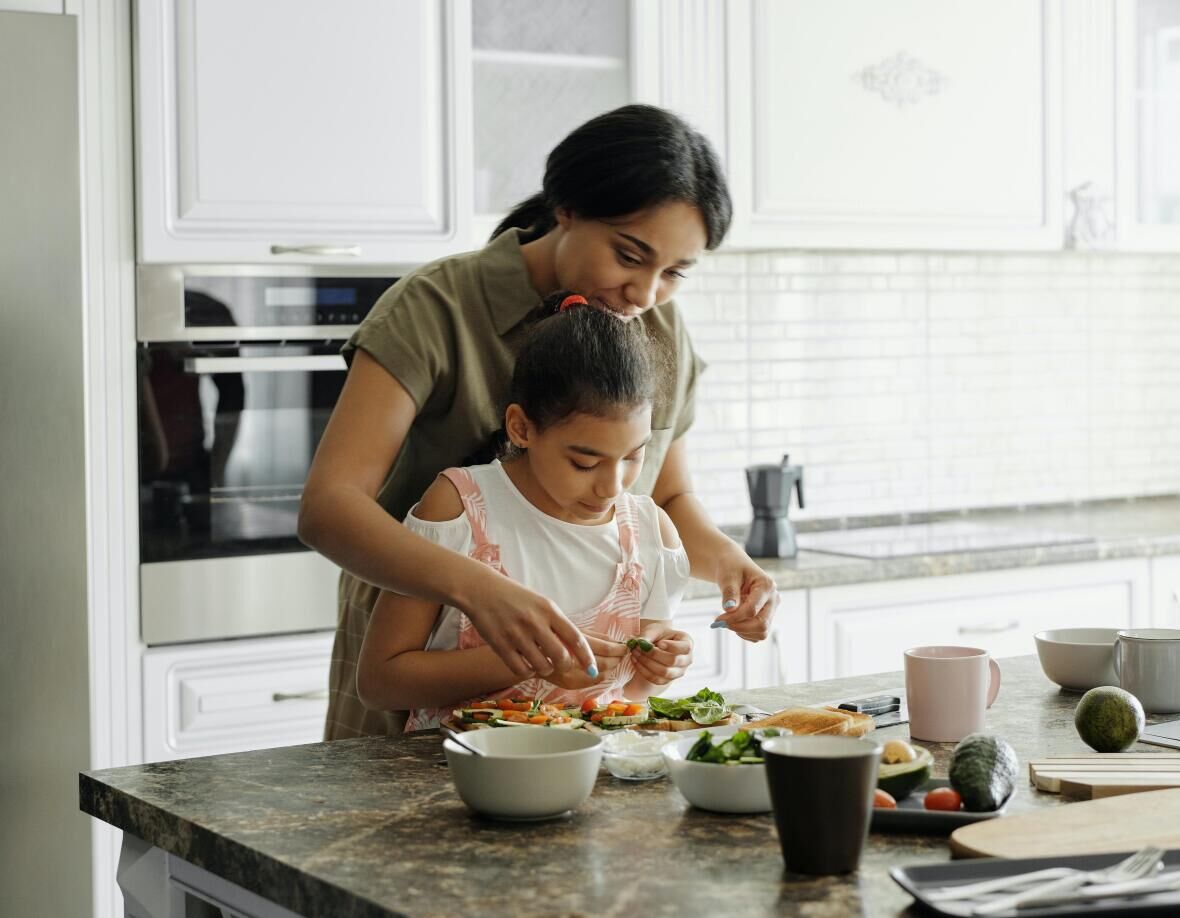 Mom and daughter preparing food together