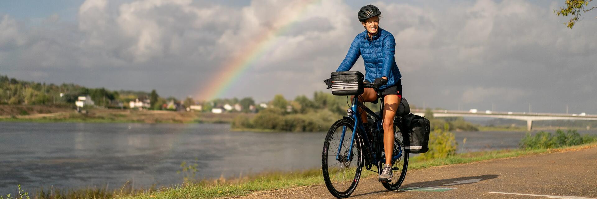 Kobieta w kasku jadąca rowerem po opolskiej trasie rowerowej