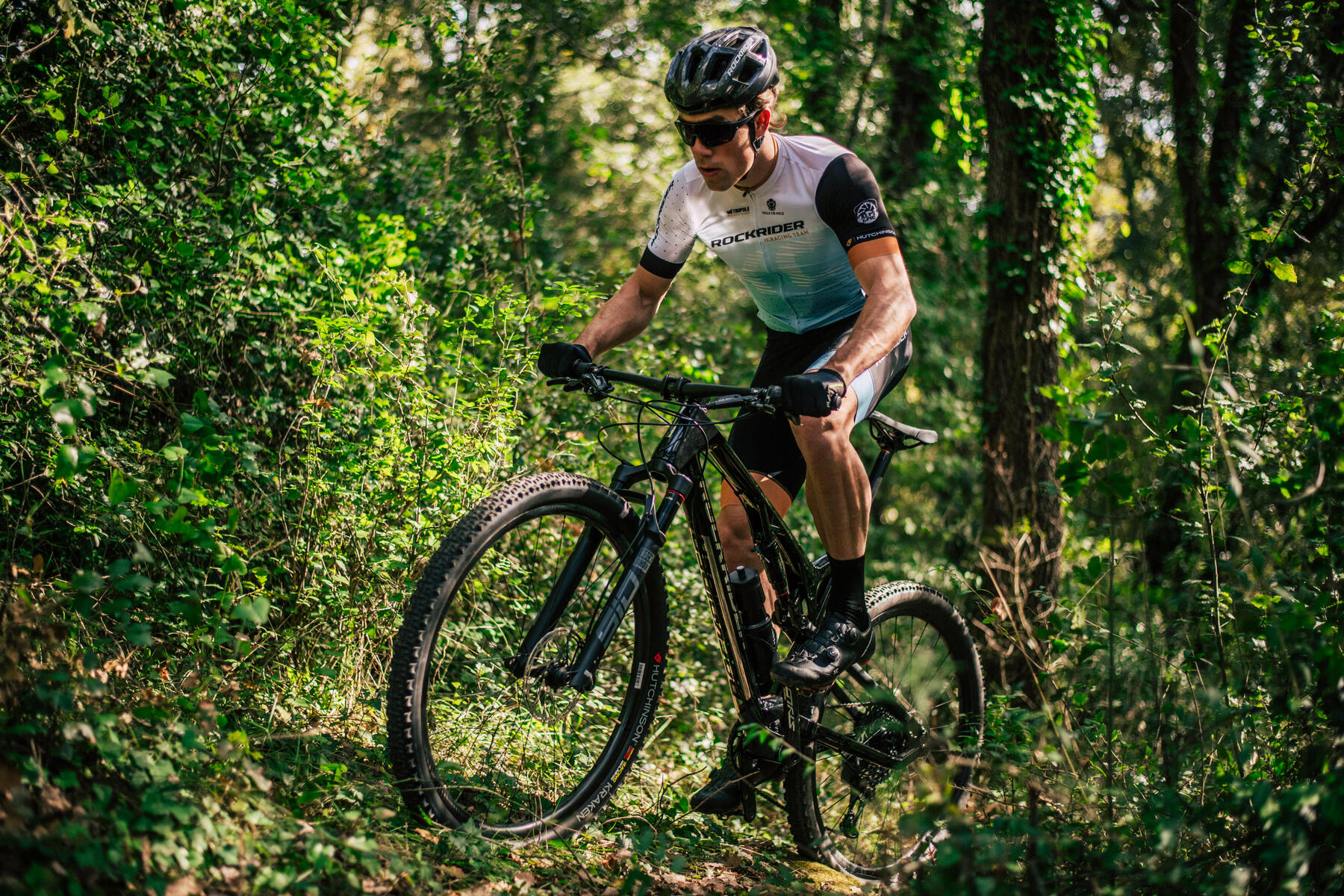 Man riding a mountain bike in a green foresty area