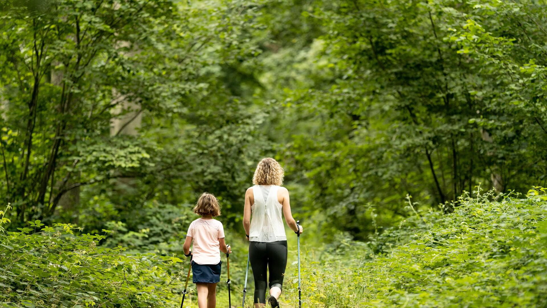 Frau und Kind mit Nordic Walking Stöcken
