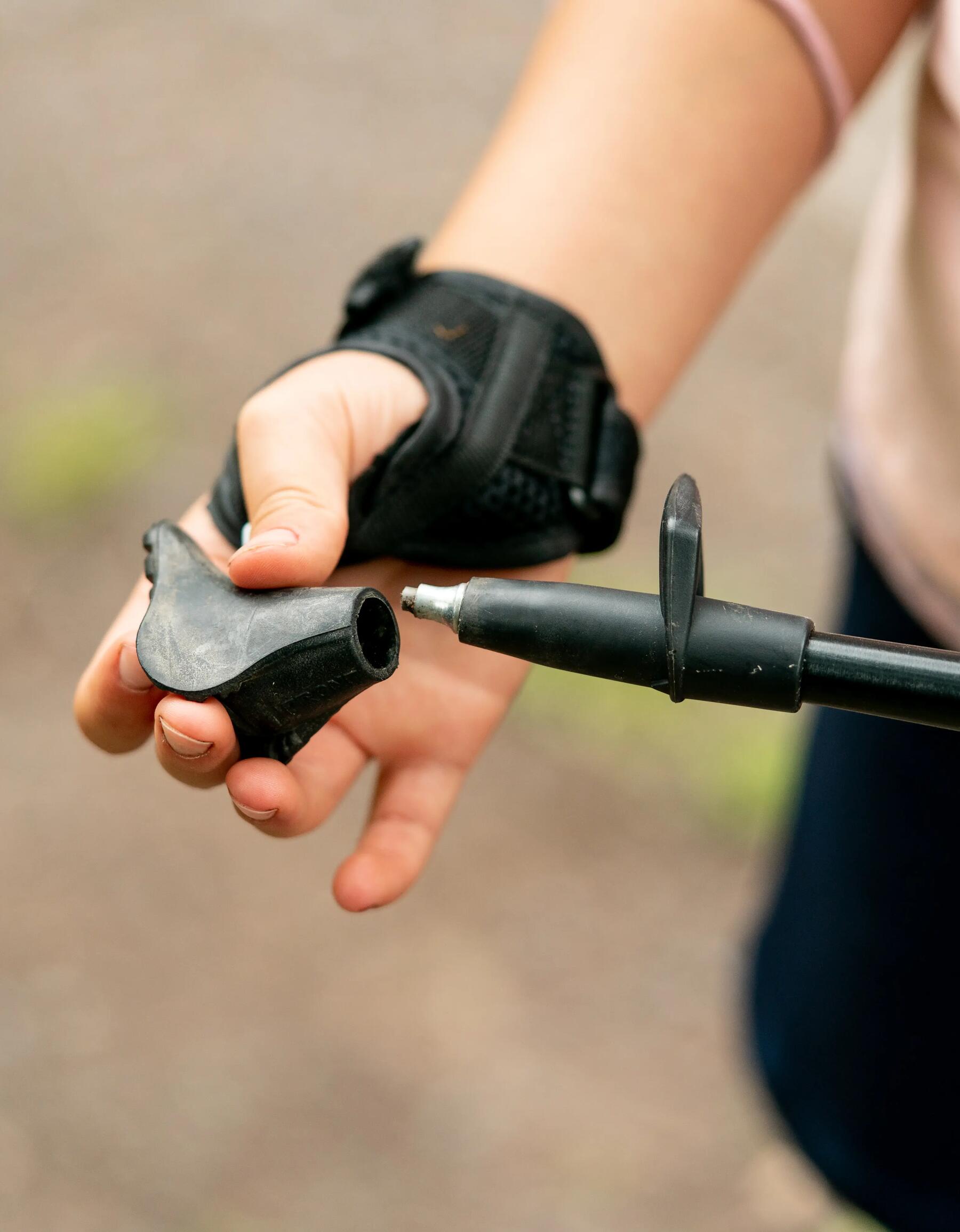 Frau prüft den Fuß ihres Nordic Walking Stocks