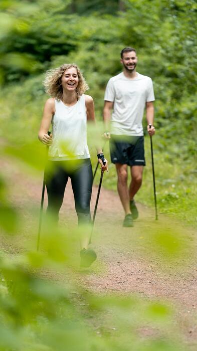 Muž a žena s paličkami počas nordic walkingu