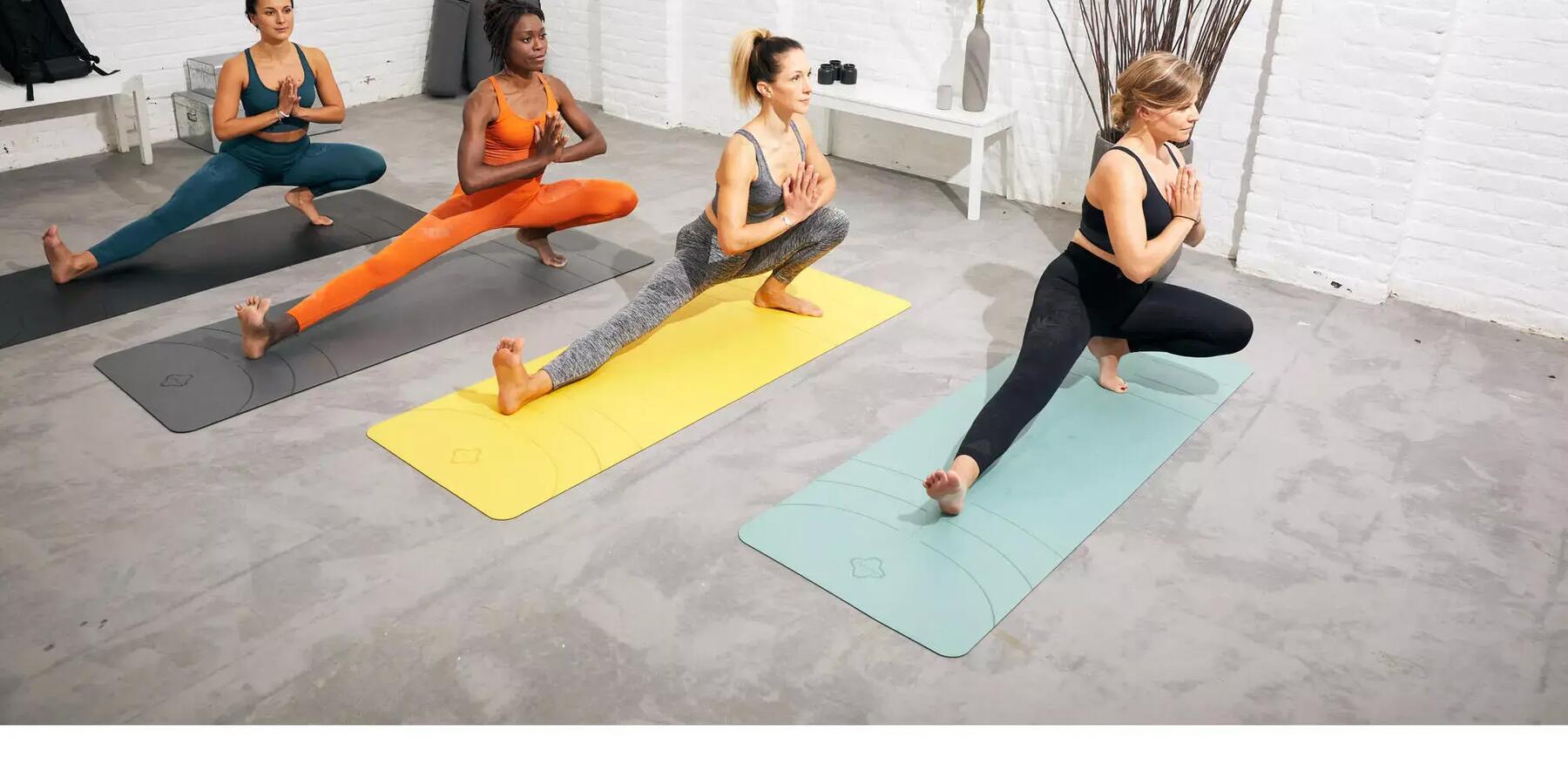 Vier frauen machen Yogaübungen auf Gymnastikmatten