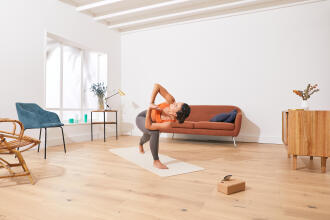 une femme qui fait du yoga dans son salon