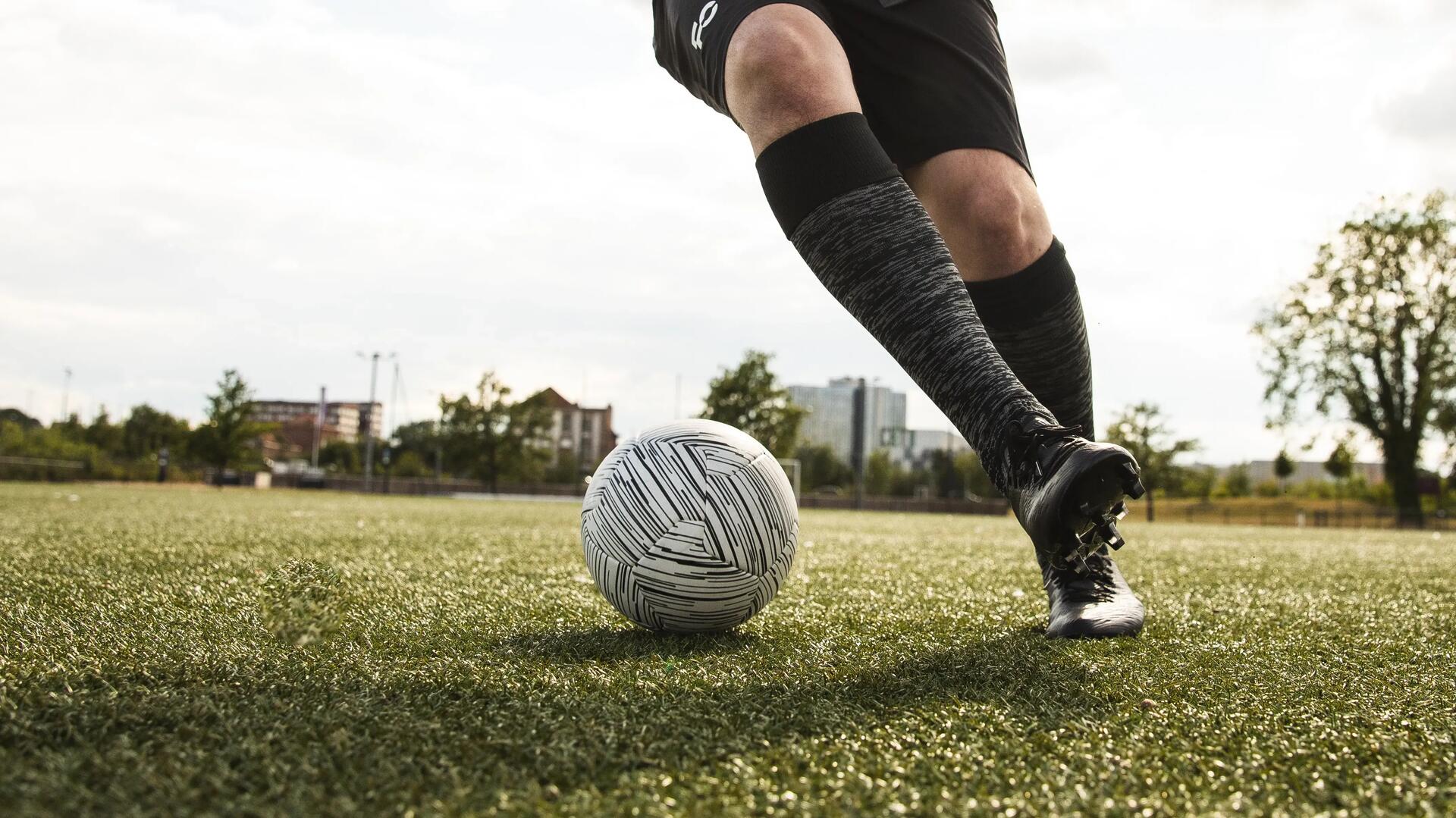 Voetballer die dribbelt op het voetbalveld