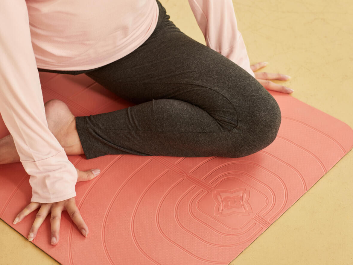 woman working on her flexibility on a yoga mat