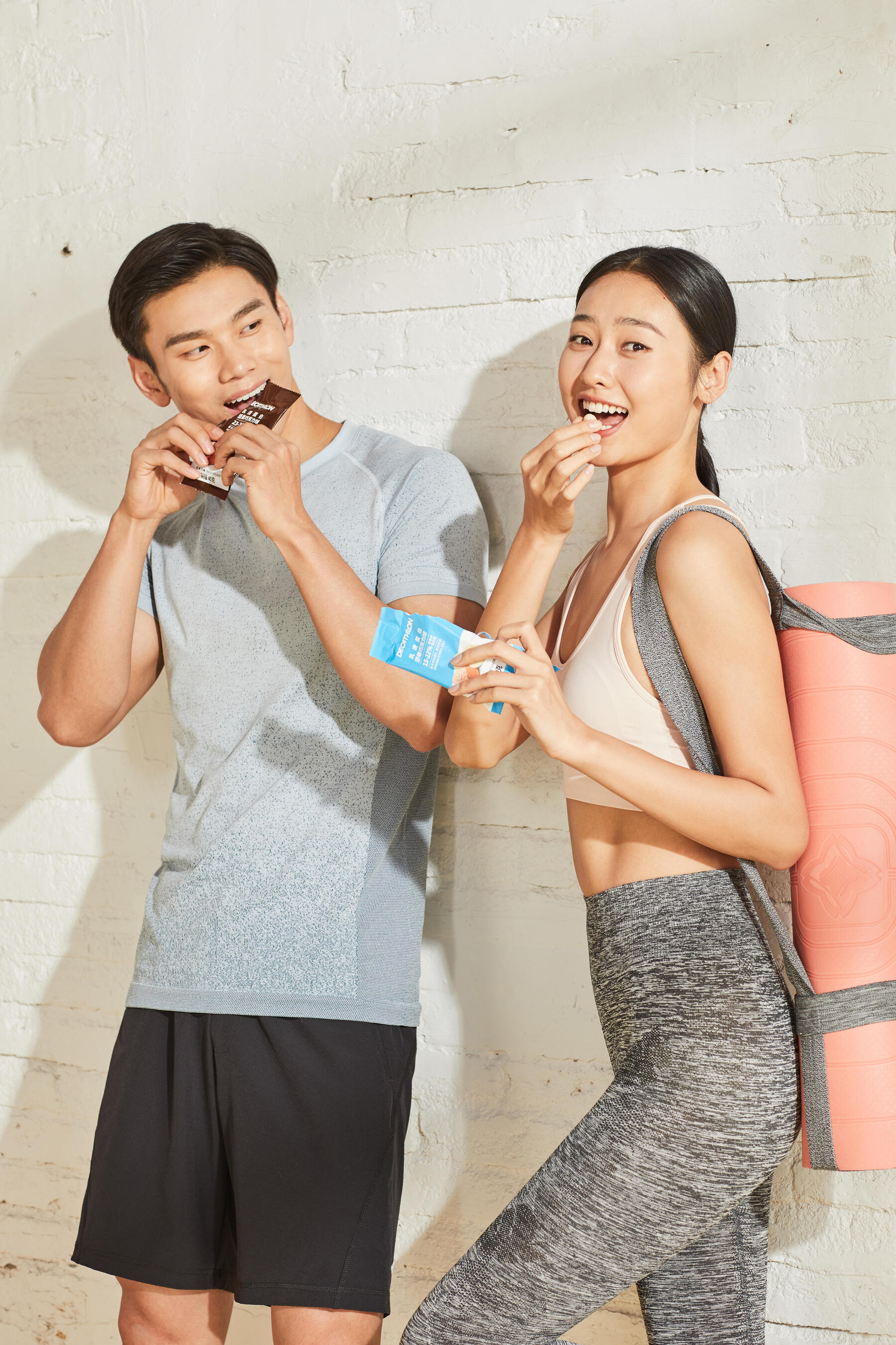 Kobieta i mężczyzna jedzący batonika po treningu unikając restrykcyjnej diet
