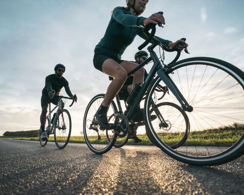 Rowerzyści w strojach sportowych i kaskach rowerowych jadący na rowerach z amortyzatorami