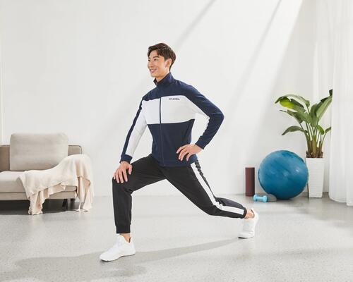 Ein Mann dehnt sich im Wohnzimmer vor und nach dem Sport