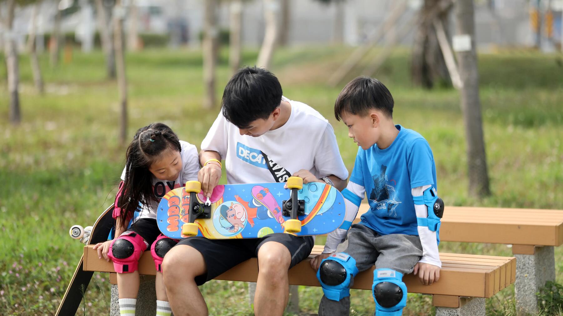 Kinder beobachten interessiert, wie ein Erwachsener die Rollen eines Skateboards montiert