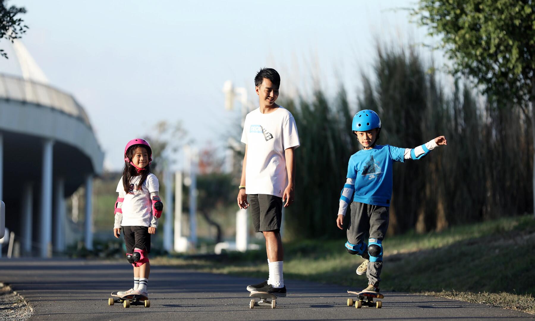 a man and two kids riding their skateboards