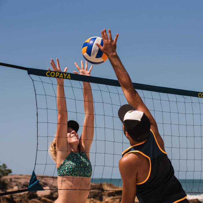 Muž a žena hrajúci plážový volejbal