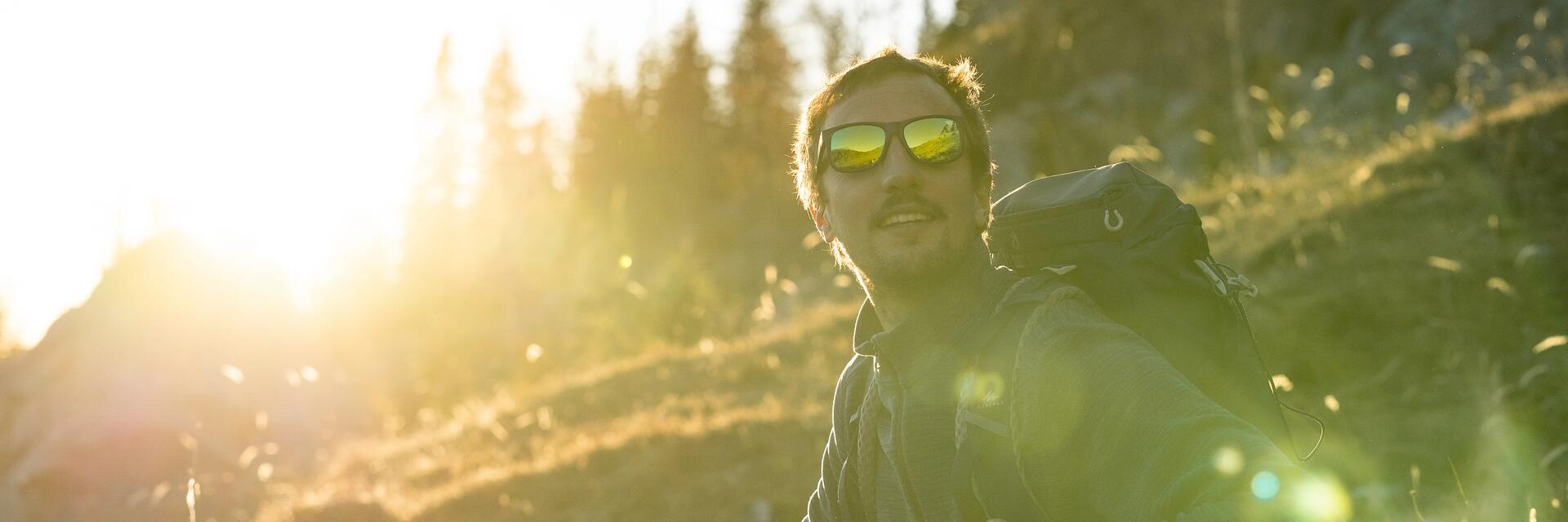 Ein Mann trägt eine Sonnenbrille zum Wandern