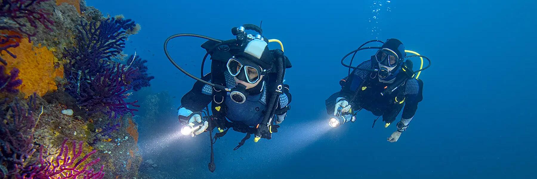 Tauchanfänger beim ersten Tauchgang in einer bunten Unterwasserwelt