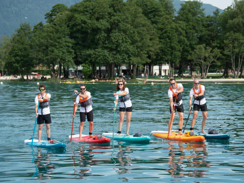 group of people practicing stand up paddle