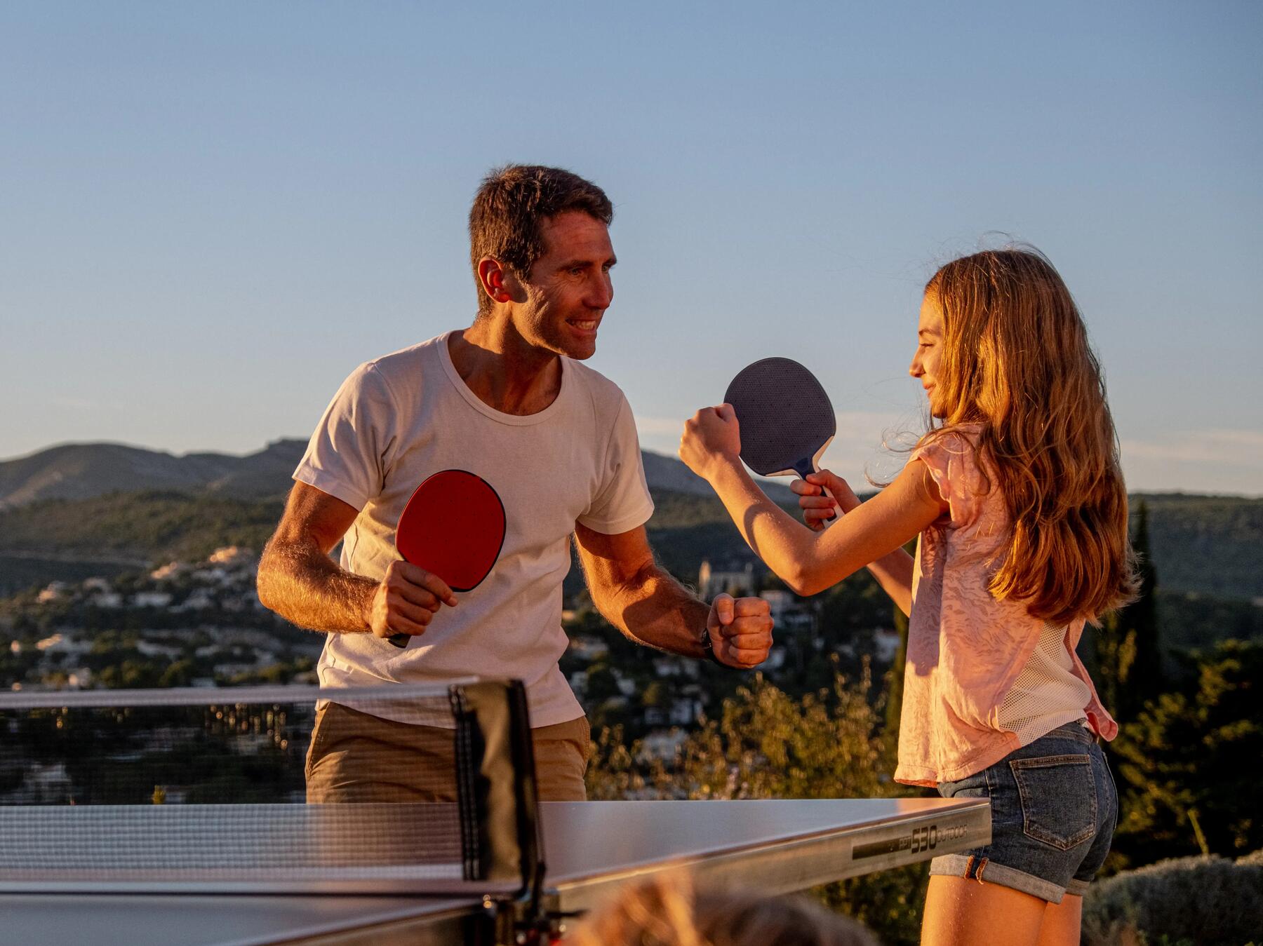 Ojciec z córką cieszący się ze zdobycia punktu w grze w debla w tenisa stołowego