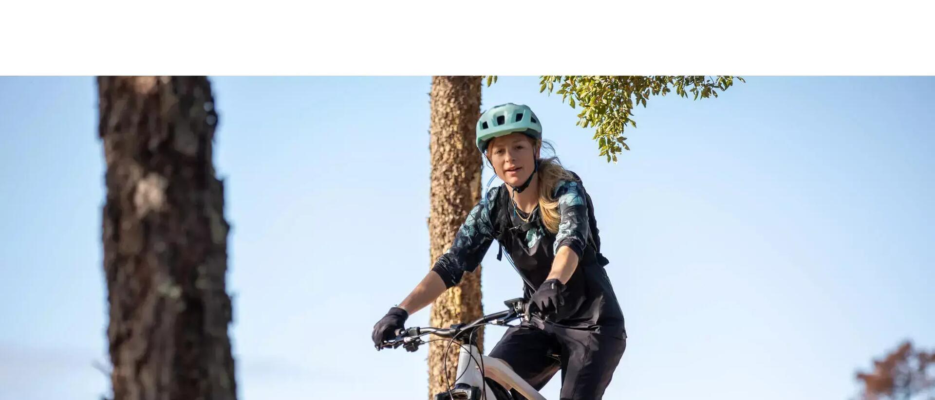 kobieta jadąca na rowerze w spodenkach rowerowych i kasku
