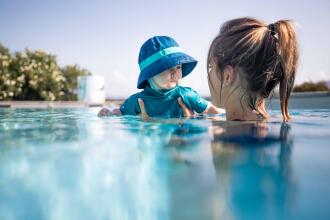 Baby in a pool with his mom