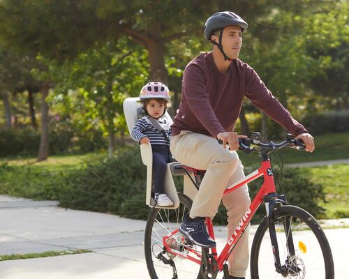 Ein Mann fährt mit dem Fahrrad und sein Kind ist im Kindersitz
