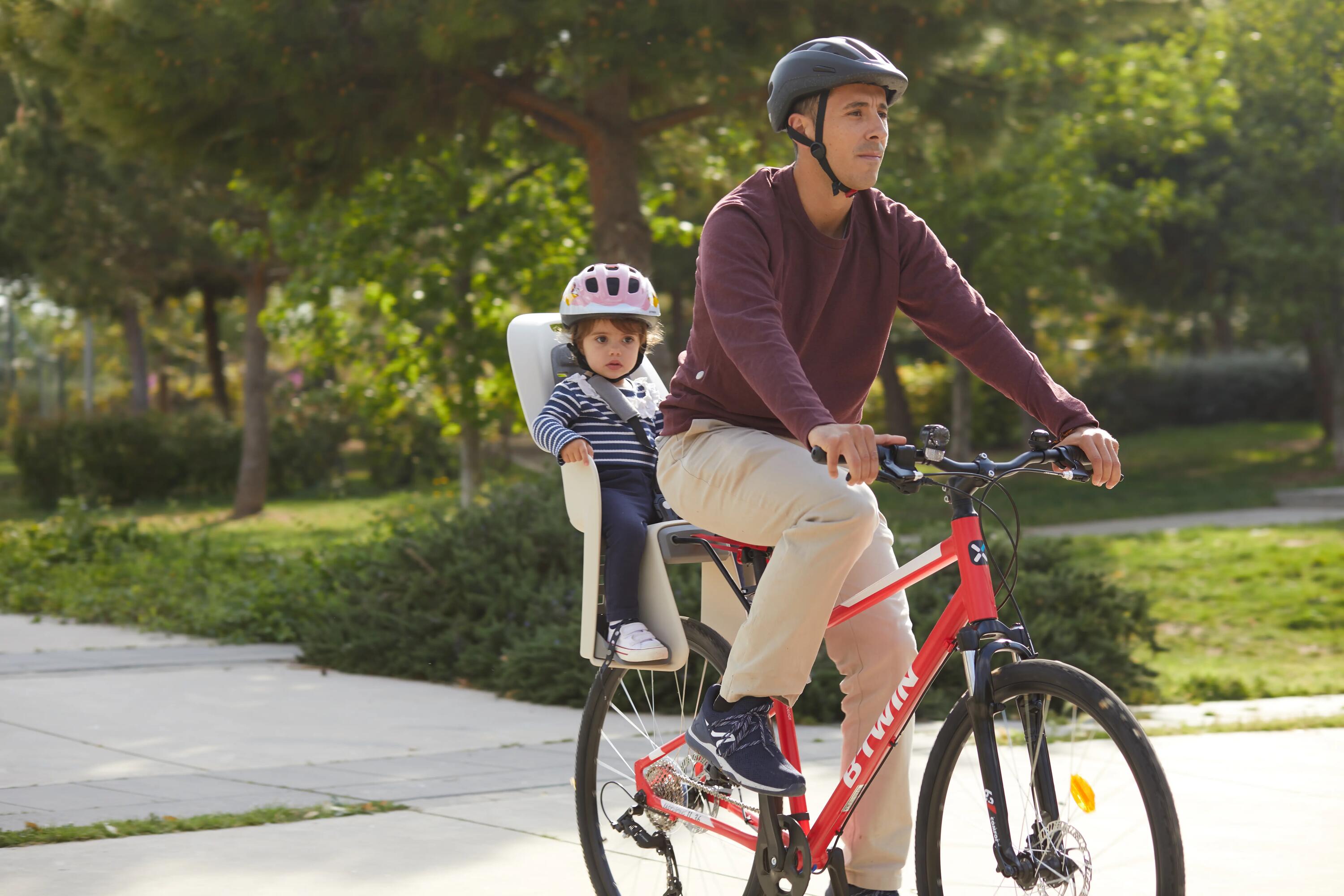 Ein Mann fährt mit dem Fahrrad und sein Kind ist im Kindersitz