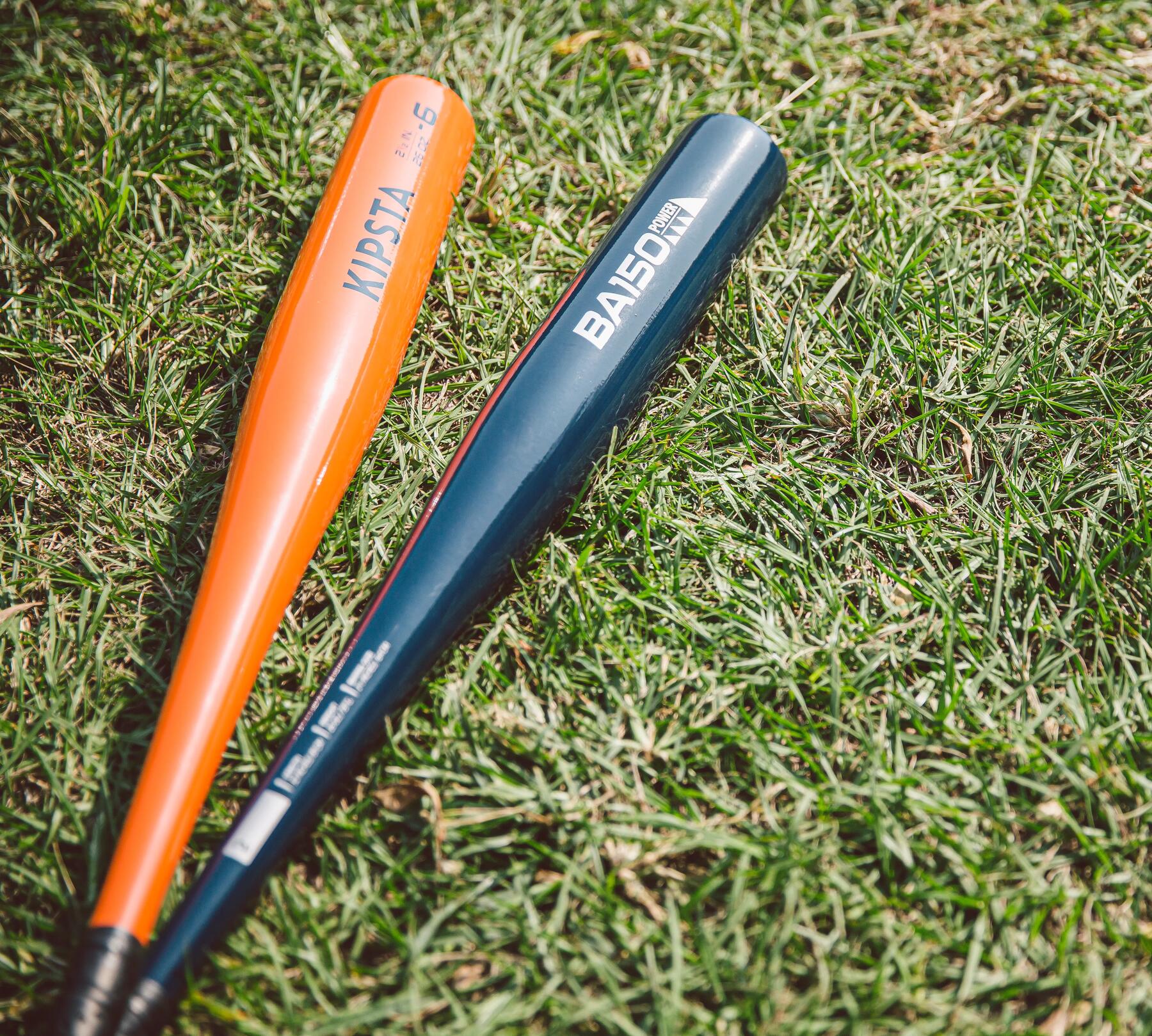 two baseball bats on the grass