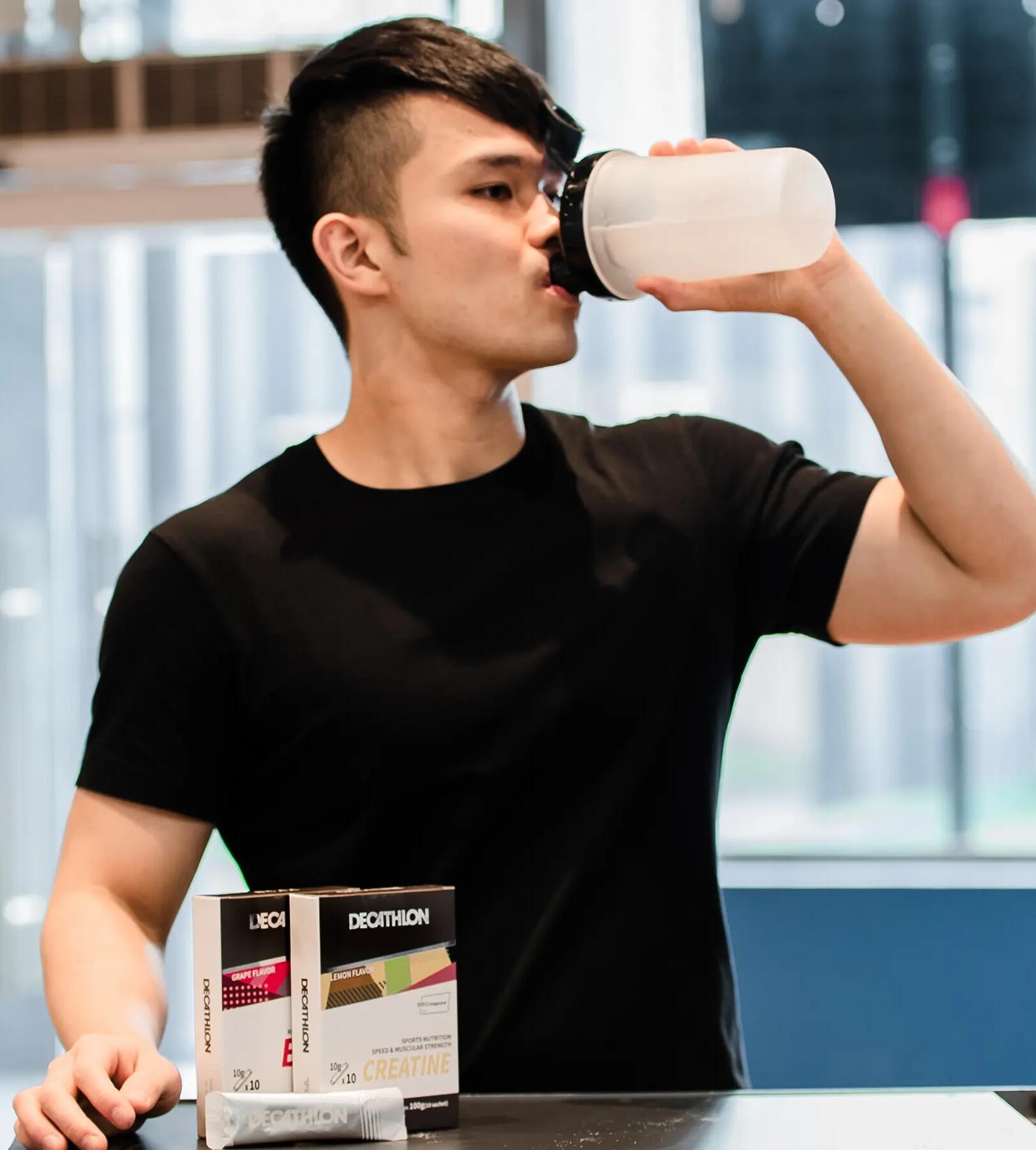 mężczyzna pije shake'a przed siłownią